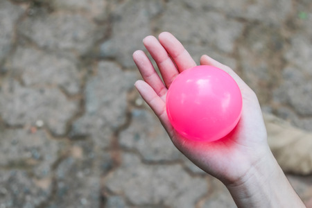Pink plastic balls on girl hand backgroundの写真素材