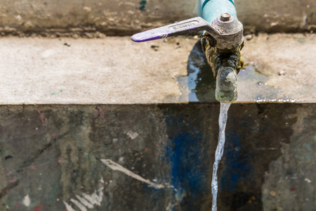 water source rusty valve, pipe, tap with moss on itの写真素材