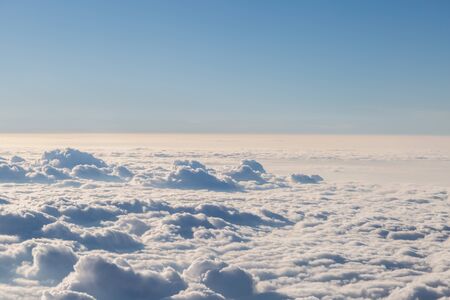 Fluffy white clouds and blue sky seen from airplane for backgroundの写真素材