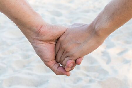 lover hold hand on the beach with sand waveの写真素材