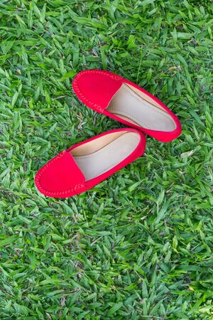 Red shoes girl on green grass backgroundの写真素材