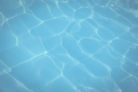 Vintage Blue pool water with sun reflections background