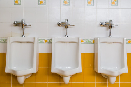 white urinals in men's restroom public toiletsの写真素材