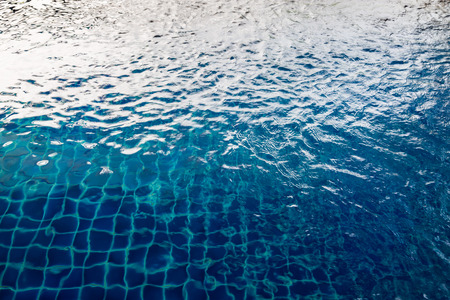 swimming pool sun reflection with blue mosaic backgroundの写真素材