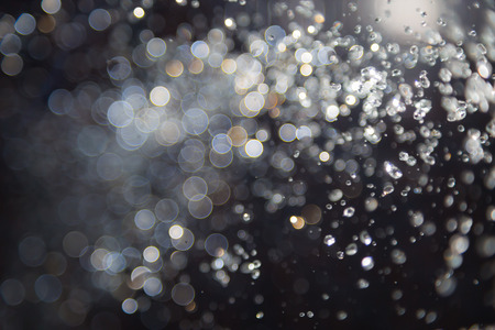 bokeh of water fly and lights on black backgroundの写真素材