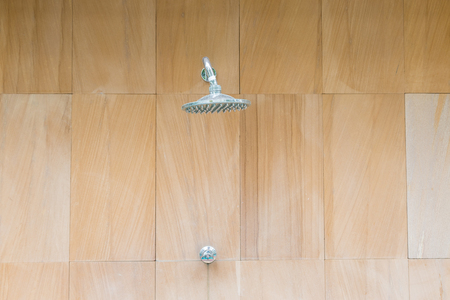 Outdoor shower sprinkler on brown wall backgroundの写真素材