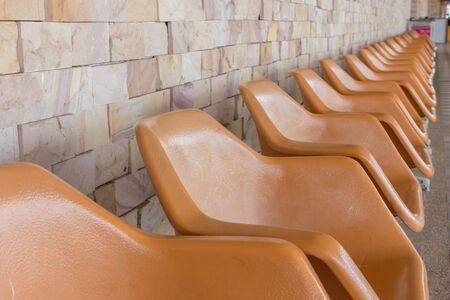 Row of empty seats with stone wall use for backgroundの写真素材