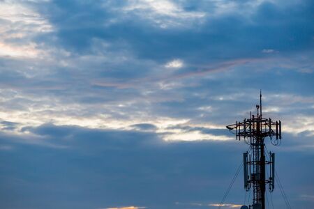 Black silhouette Cellular tower with sky and clouds before sunset use for backgroundの写真素材