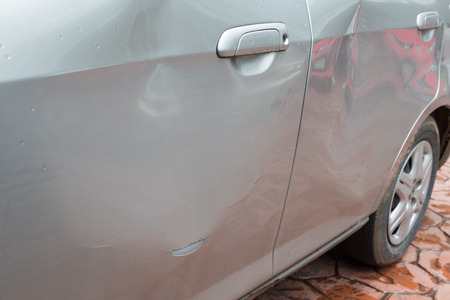 Door car with damage on accident with dent on left side on raining dayの写真素材