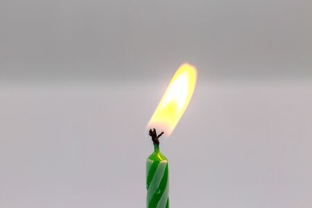 Green birthday candle on white backgroundの写真素材