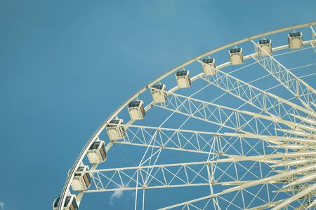 Vintage White big Ferris wheel  with blue sky sharp clouds  backgroundの写真素材