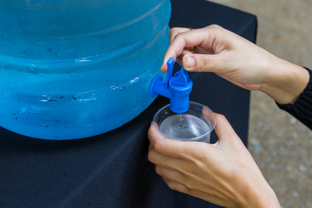 Female hand holding water glass backgroundの写真素材