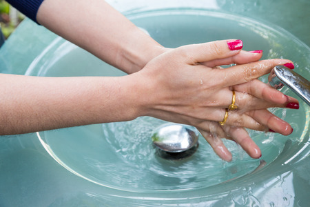 Woman with red nail Cleaning Hands, Washing hands on blue sink backgroundの写真素材