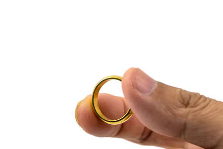 Closeup photo of  golden wedding ring on hands isolated on white backgroundの写真素材