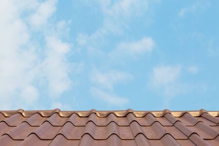 Roof house with tiled roof on blue sky backgroundの写真素材