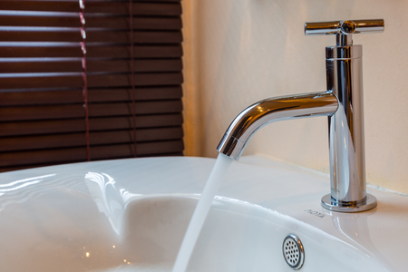 Modern chrome tap faucet with running water use for backgroundの写真素材