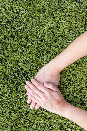 girl hand on soccer field grass backgroundの写真素材