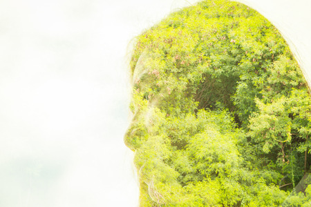 Double exposure of face woman with tree branches and leaves backfeound