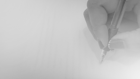Close-up of woman hands with pens over empty documents backgroundの写真素材