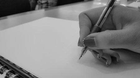 Close-up of woman hands with pens over empty documents backgroundの写真素材
