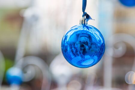 Christmas balls hanging on ribbon with bokeh backgroundの写真素材