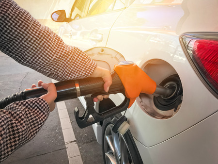Woman refueling car  at the gas station backgroundの写真素材