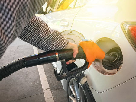 Woman refueling car  at the gas station backgroundの写真素材