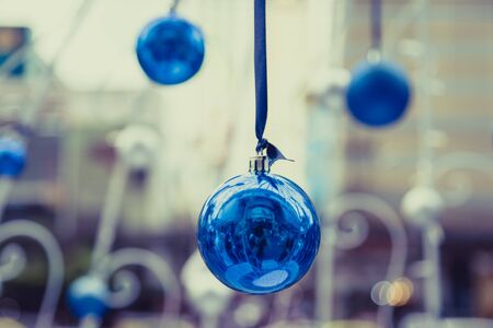 Christmas balls hanging on ribbon with bokeh backgroundの写真素材