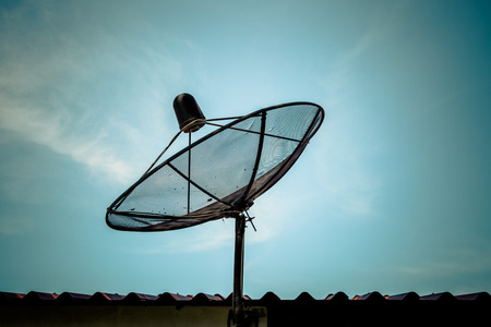 Old satellite dish on blue sky baclgroundの写真素材