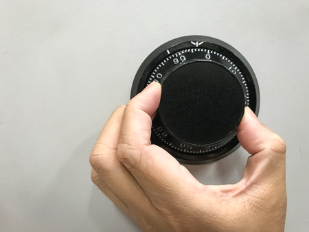 Hand is rotating the security code of safe backgroundの写真素材