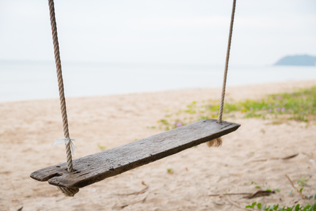 Wood swing at the beach and sand backgroundの写真素材