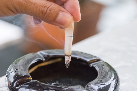 Hand hold cigarettes going to quit smoking backgroundの写真素材