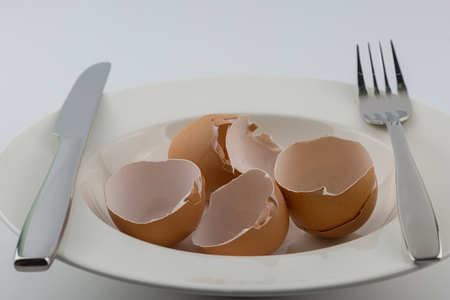 Egg shell on white plate diet concept backgroundの写真素材