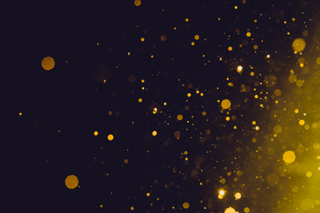 Abstract gold bokeh on black backgroundの写真素材