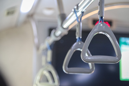Hand holding safety straps, Hanging handle, plastic grab handle inside the public transportの写真素材