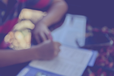 Blur image of man fill out application with camera and smart phone on the table backgroundの写真素材