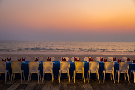 Dining table at the beach during sunset backgroundの写真素材