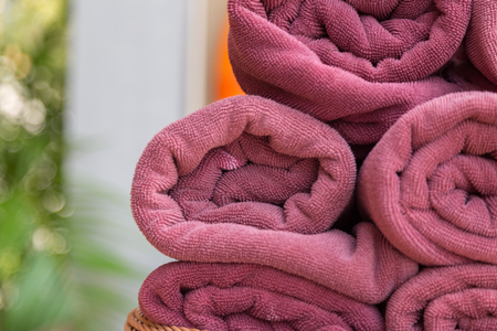 Roll the towel on a rattan basket with green bokeh backgroundの写真素材