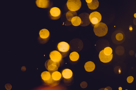 Dark Abstract Gold bokeh sparkle on black backgroundの写真素材