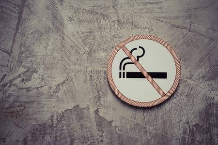No smoking sign on the gray cement wall backgroundの写真素材