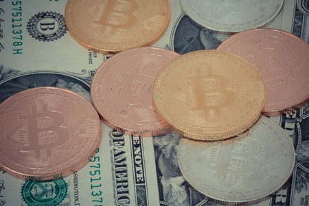 crypto currency gold silver bronzen bitcoin with dollar banknotes backgroundの写真素材