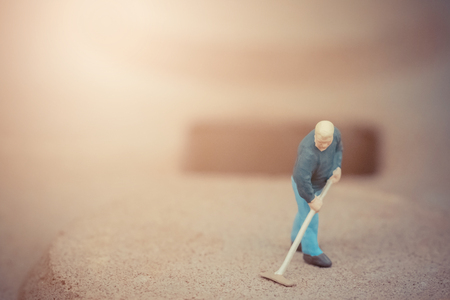 Miniature people cleaning the floor backgroundの写真素材