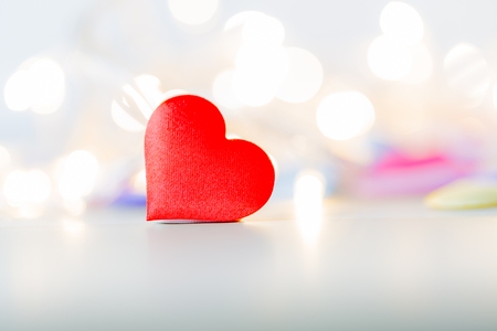 Red heart shape on wood table with soft bokeh backgroundの写真素材