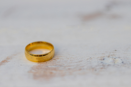 Golden rings, wedding rings of the bride and groom on white vintage wooden backgroundの写真素材