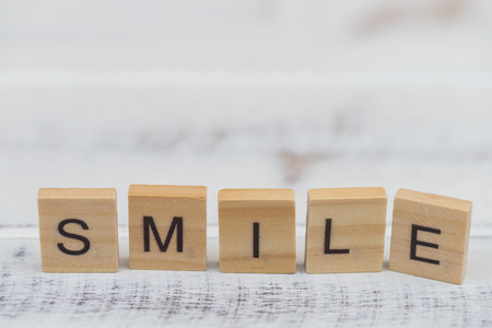 Alphabet smile word on white old vintage wood backgroundの写真素材