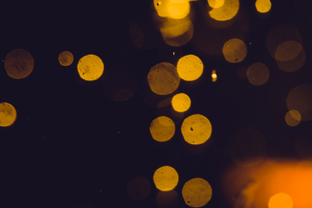 Dark Abstract Gold bokeh sparkle on black backgroundの写真素材