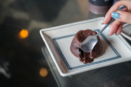 Chocolate cupcake with dark chocolate icing bakeh backgroundの写真素材