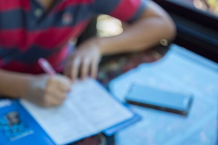 Blur image of man fill out application with camera and smart phone on the table backgroundの写真素材