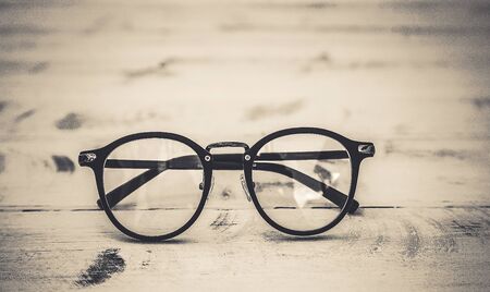Black frame clear glasses on vintage table backgroundの写真素材