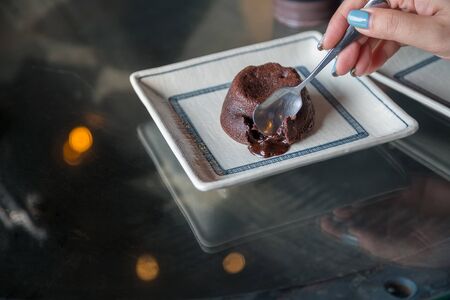 Chocolate cupcake with dark chocolate icing bakeh backgroundの写真素材